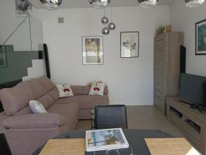 a living room with a couch and a tv at Casa Spruit in Rojales