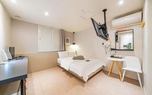 a bedroom with a bed and a desk and a mirror at Hotel Yam Bucheon Station in Bucheon