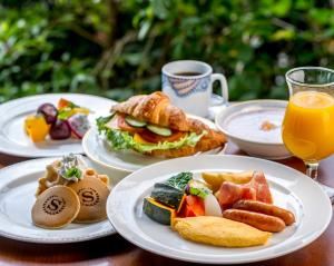 een tafel met borden en een kop sinaasappelsap bij Sheraton Grande Ocean Resort in Miyazaki