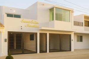 a house with garage doors in front of it at Sunset Suites Mazatlán at Lomas de Mazatlán in Mazatlán