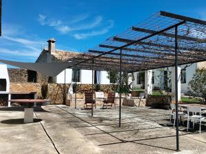 a pergola with chairs and tables on a patio at Malpesa Rural in Poveda de la Obispalía +72 photos