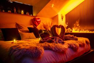 a bedroom with a bed with a blanket and a fireplace at Love Room Serenity Suite in Montbéliard