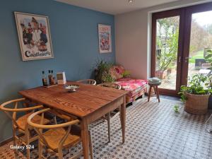 a dining room with a wooden table and chairs at Chambre de Arnaud à Gerpinnes in Gerpinnes