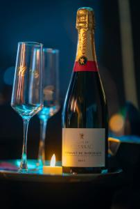 a bottle of wine sitting next to a wine glass at Love Room Serenity Suite in Montbéliard