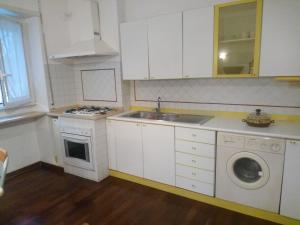 ローマにあるLa Casa di Nonna Bettaの白いキャビネット、シンク、食器洗い機付きのキッチンが備わります。