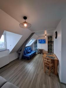 a living room with a blue couch and a table at Studio l'écluse in Le Tréport