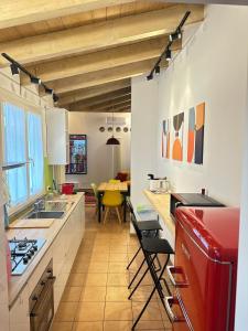 a kitchen with white cabinets and a red refrigerator at Dimora Farnese in Piacenza