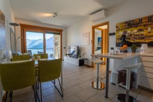 a kitchen and living room with a table and chairs at Residence degli Oleandri APP A1 in Argegno