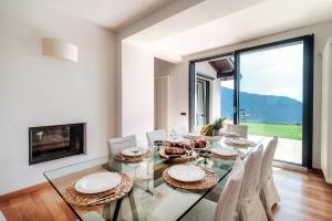 a dining room with a glass table and chairs at Villa Citriodora in Cernobbio