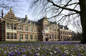 a large building with purple flowers in front of it at Van der Valk Hotel Assen in Assen