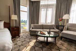 a hotel room with a bed and a couch and a table at The Magnolia Hotel & Spa in Victoria +42 photos