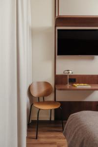 a bedroom with a chair and a desk with a television at H Regas Adults Only in Barcelona