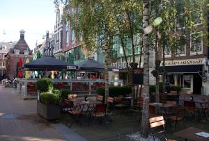 an outdoor cafe with tables and chairs on a city street at Inntel Hotels Amsterdam Centre in Amsterdam