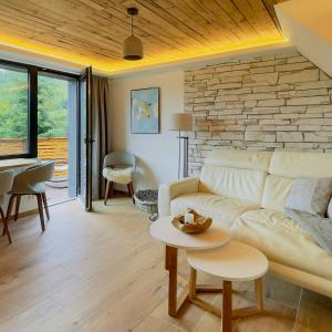 a living room with a white couch and a brick wall at Modern Birch Chalet At Ruppberg in Zella-Mehlis