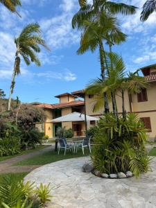a resort with palm trees and a patio at Pousada Paisagem in Paraty