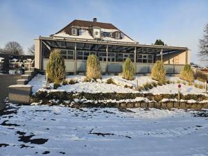 a large building with snow on the ground at Zur Schlossbrücke in Ritterhude +18 photos
