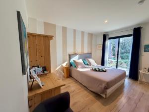 a bedroom with a bed and a large window at CARPE DIEM Résidence Hôtelière in Lorgues