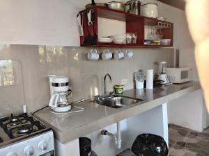 a kitchen with a sink and a coffee maker on a counter at Cabañas Martina Surf Playa Guanico in Pedregal