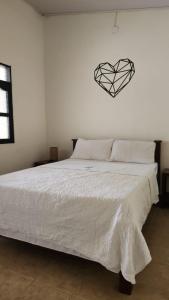a bedroom with a bed with a heart on the wall at Desiderata Resort in Guaduas