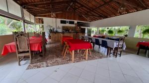 a restaurant with red and blue tables and chairs at Pousada Bosque dos Aruãs in Salvaterra