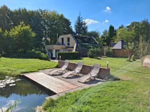 a group of chairs sitting on a wooden bridge over a pond at Ferienhaus am Mittelberg in Nordhausen