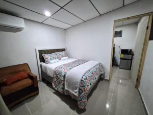 a bedroom with a bed and a chair in it at Ciudad Merliot, casa Don Pablo in Hacienda Plan de La Laguna