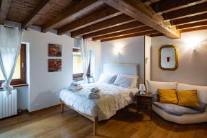 a bedroom with a bed and a chair in it at Casa agli Archi in Bardolino +76 photos
