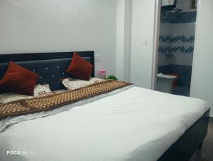 a bed with pillows on it in a bedroom at Dhananjay home stay in Dharampur
