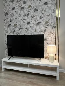 a flat screen tv sitting on top of a white entertainment center at Apartament Rynek Strzelin in Strzelin