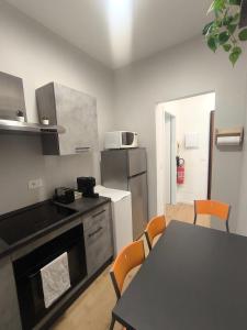 a kitchen with a table and a kitchen with a refrigerator at Zuretti House in Milan