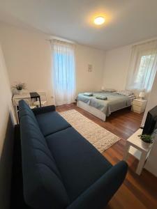 a living room with a blue couch and a bed at Dzikie Fiołki in Karpacz