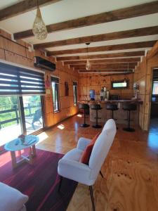 a living room with a white chair and a table at Cabaña privada con acceso a playa in Castro