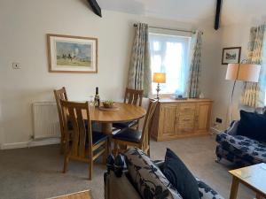 a living room with a table and a couch at The Bothy in Lyndhurst +5 photos