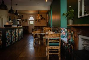 a restaurant with tables and chairs and green walls at The Smugglers Rest in Woolacombe