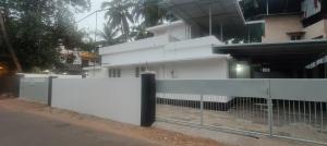 a white fence in front of a building at Ivory Suites Meadows in Kozhikode