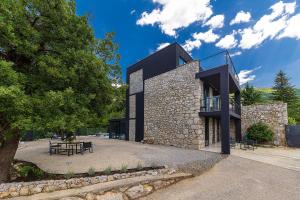 a black building with a table and benches in front of it at Villa Arija in Grižane
