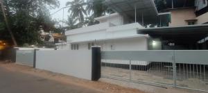 a white fence in front of a building at Ivory Suites Meadows in Kozhikode +4 photos