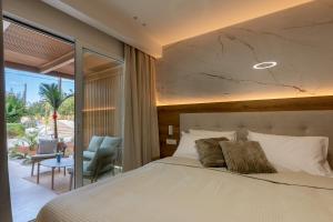 a bedroom with a bed and a view of a patio at Nadia Suites Residencess Adults Only in Malia +274 photos