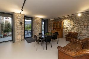 a dining room with a table and a stone wall at Villa Arija in Grižane