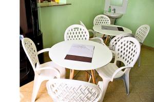 a group of white tables and chairs with laptops on them at Mamboleo princely Homes in Kisumu