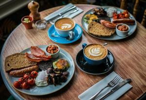 a table with two plates of food and two cups of coffee at The Smugglers Rest in Woolacombe +8 photos