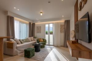 a living room with a couch and a tv at Nadia Suites Residencess Adults Only in Malia