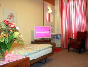 een kamer met een flatscreen-tv in een kamer bij BasicRooms Hotel in Interlaken