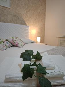 a bed with white towels and a plant on it at Sciara casa vacanze in Viagrande