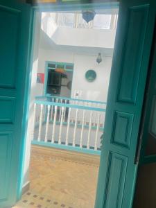 a door leading into a room with a crib at Riad darkoum in Essaouira