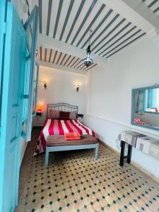 a bedroom with a bed in a room at Riad darkoum in Essaouira