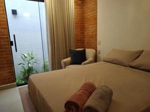 a bedroom with a bed and a chair and a window at Casa em local tranquilo - Bairro Recanto dos Pássaros in Cuiabá +30 photos