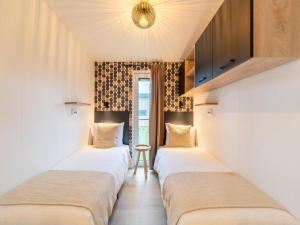 two beds in a row in a room at Bij de Bakker in Oud-Ade
