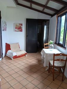 a room with a table and a couch and a table and chair at Acacia Retreat in Île La Fond
