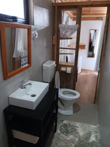 a bathroom with a sink and a toilet at Acacia Retreat in Île La Fond +2 photos